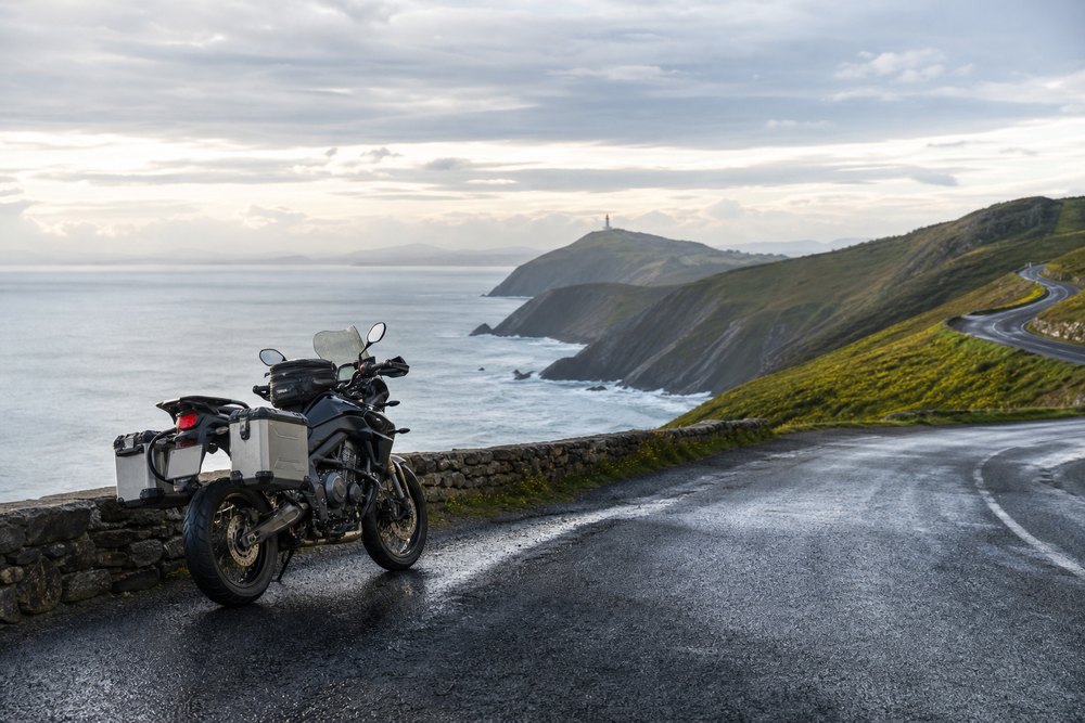 Moto en una carretera de costa y montaña de la ruta Transcantábrica
