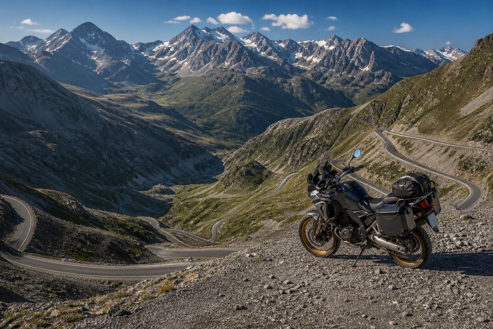 Carretera de alta montaña pirenaica al amanecer con una motocicleta equipada.